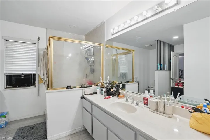 Full bathroom featuring a stall shower, vanity, and light wood finished floors