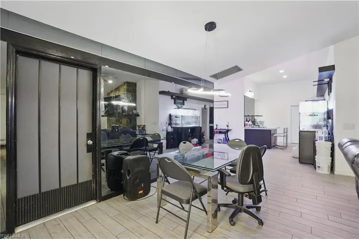 Dining room with light wood-type flooring and recessed lighting