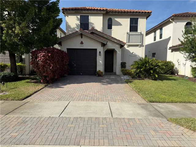 Mediterranean / spanish home featuring stucco siding, a front yard, a tile roof, a garage, and decorative driveway