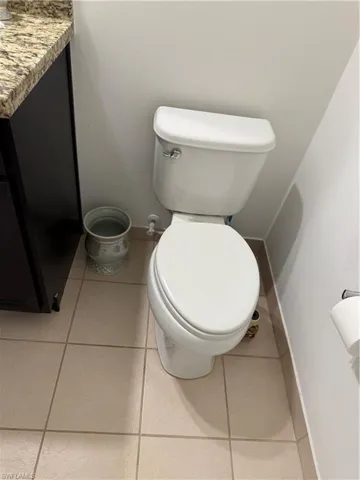 Half bathroom with baseboards and tile patterned flooring