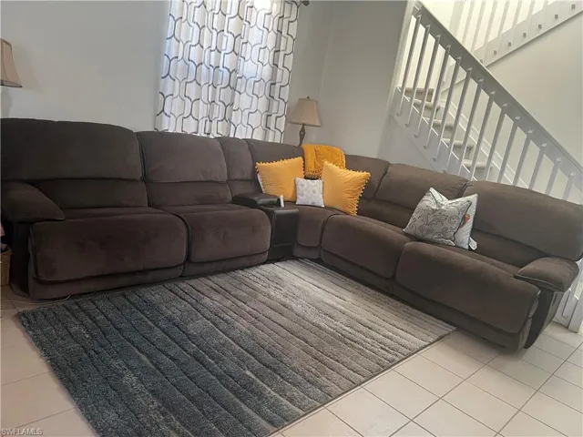 Living area featuring light tile patterned flooring and stairway