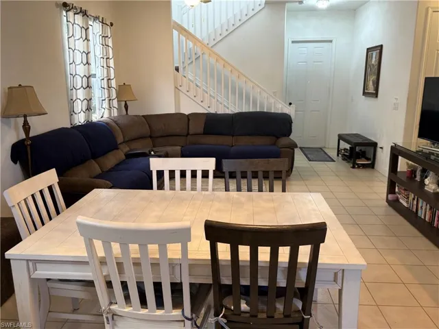 Dining area featuring light tile patterned floors and stairway