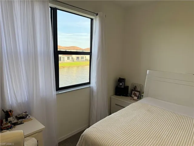 Bedroom with a water view and carpet
