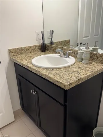 Bathroom with light tile patterned floors and vanity