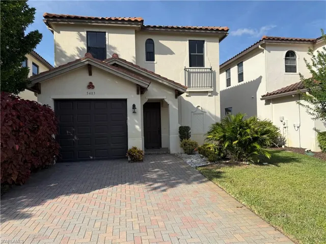 Mediterranean / spanish-style home featuring stucco siding, a tiled roof, decorative driveway, and a front lawn