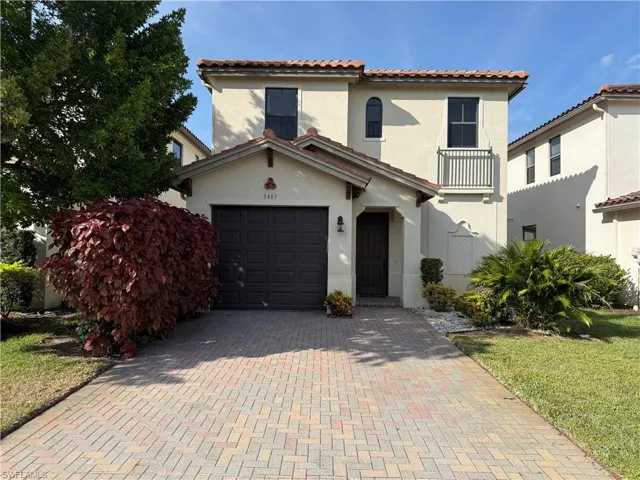 Mediterranean / spanish house featuring a tile roof, stucco siding, a garage, decorative driveway, and a front lawn