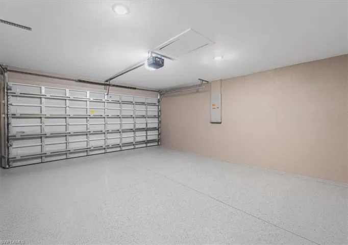 Garage featuring electric panel and a garage door opener