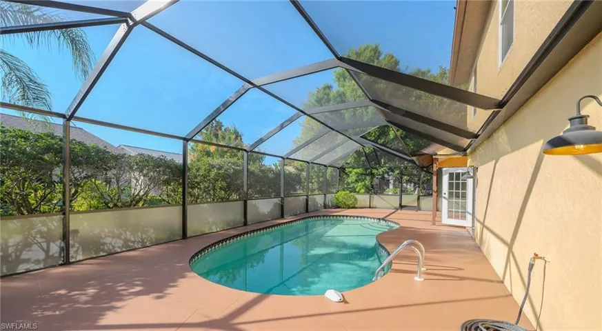 Swimming pool with a sunroom, a patio area, and a lanai