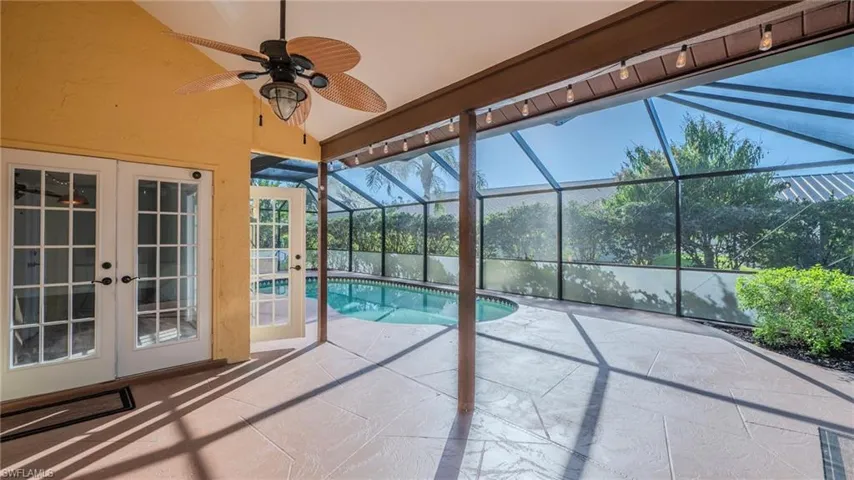Outdoor pool with a sunroom, a patio, french doors, and glass enclosure