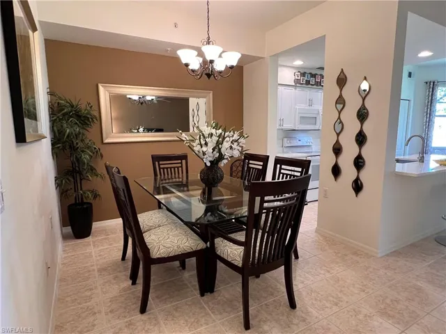 Dining space featuring a notable chandelier, light tile patterned floors, and sink