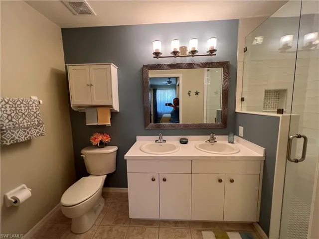 Bathroom featuring vanity, an enclosed shower, toilet, and tile tiled floors