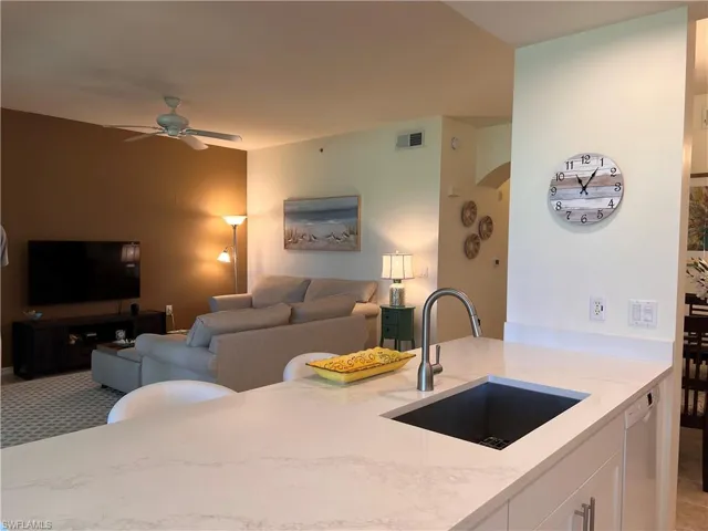 Kitchen with white cabinets, light quartz countertops, dishwasher, and large sink