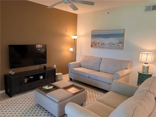 Living room featuring ceiling fan and view of the golf course