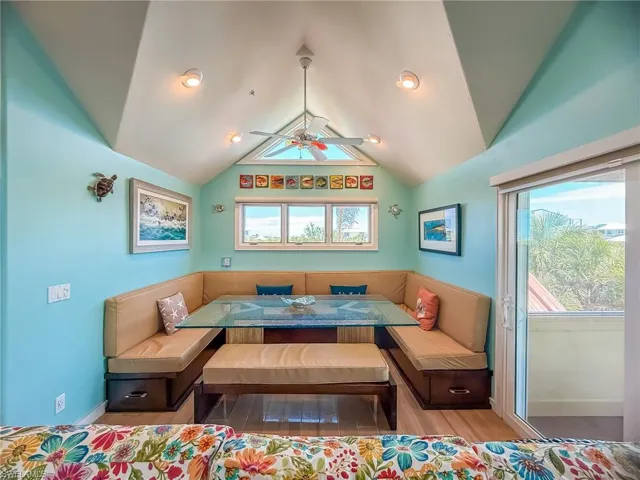 Bedroom with lofted ceiling, multiple windows, and wood finished floors