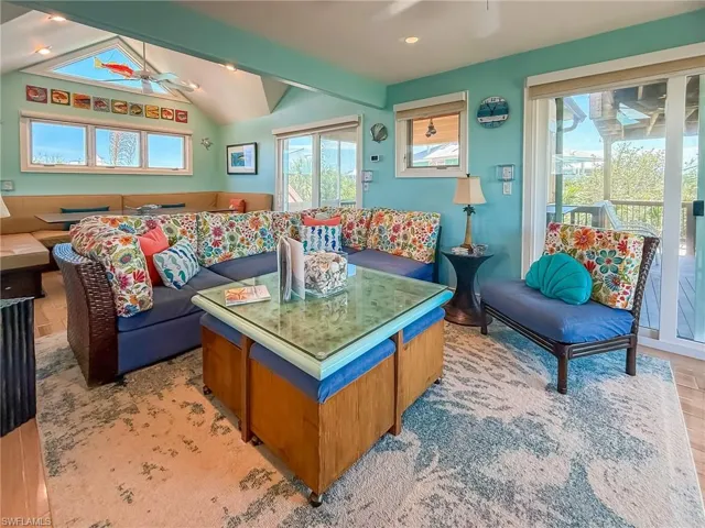 Living area with vaulted ceiling with beams and a ceiling fan