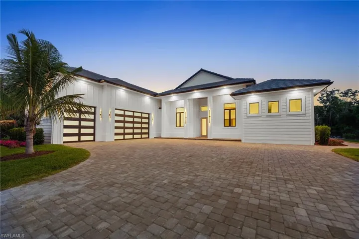 View of front of home with a garage, decorative driveway, and a tile roof
