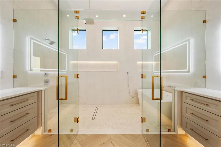 Full bathroom with tile walls, a shower stall, and vanity