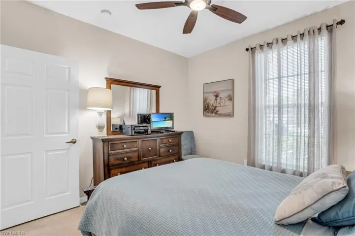 Carpeted bedroom featuring ceiling fan