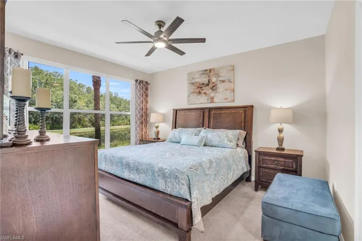 Bedroom with light colored carpet and ceiling fan