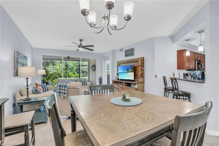 Tiled dining area with ceiling fan with notable chandelier