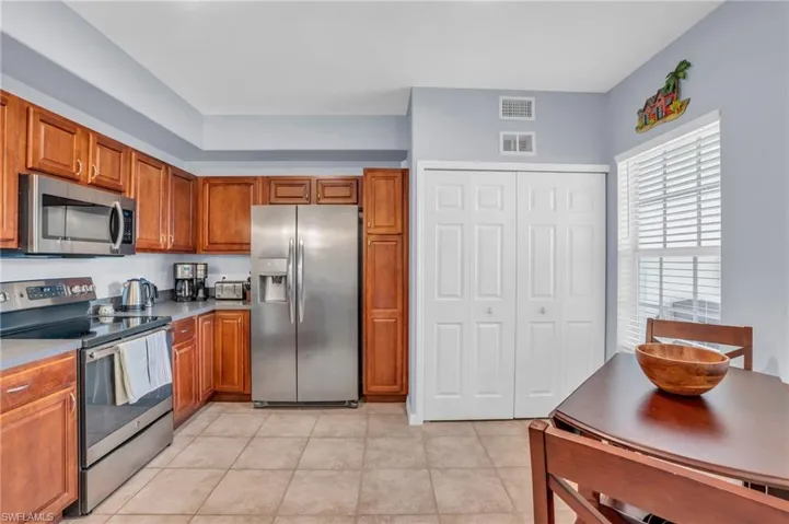 Kitchen with light tile flooring and newer stainless steel appliances