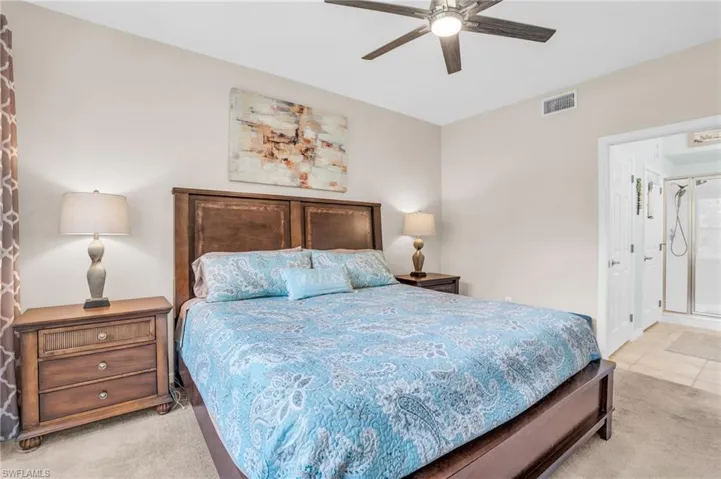 Bedroom with ceiling fan and light tile flooring