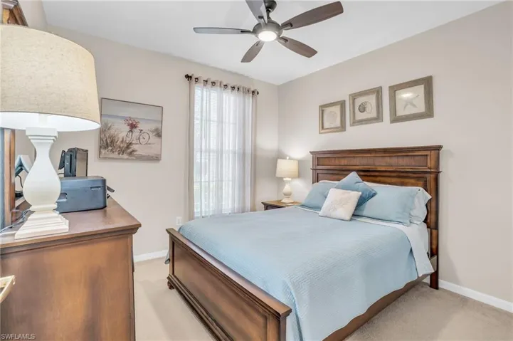 Carpeted bedroom featuring ceiling fan