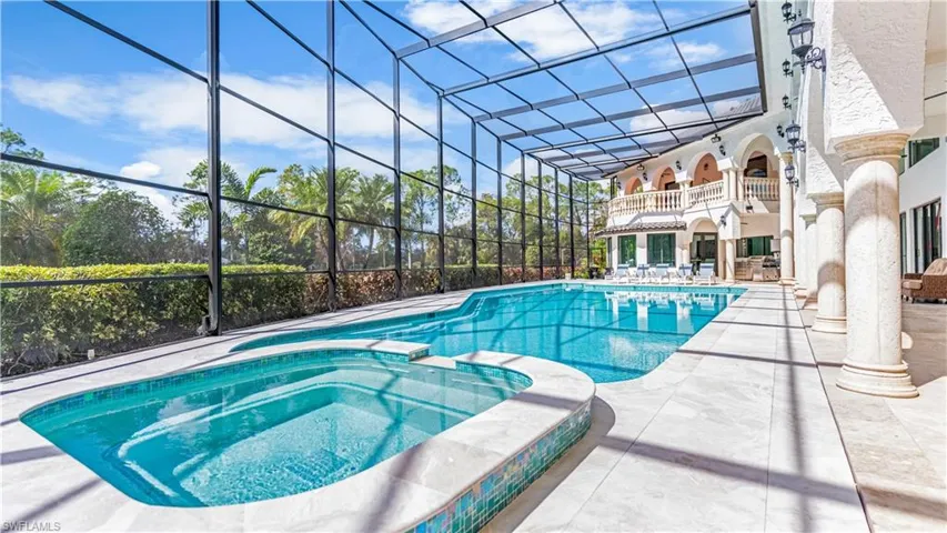 Combined pool / hot tub with a lanai, a patio area, and a balcony