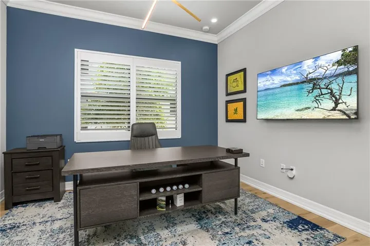 Office area featuring crown molding and light wood-style flooring