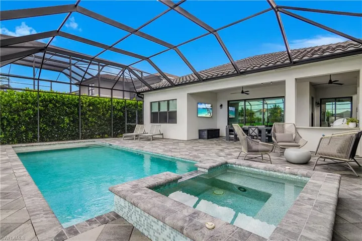 View of pool featuring a sunroom, a pool with connected hot tub, a patio, ceiling fan, and a lanai