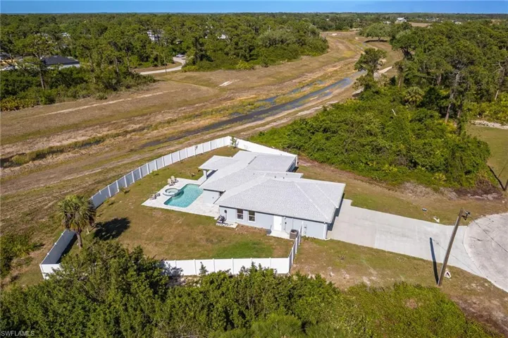 Birds eye view of property featuring a wooded view