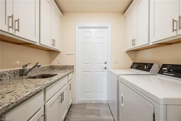 Clothes washing area with cabinet space, a sink, and separate Speed Queen washer and dryer, Built to Last!
