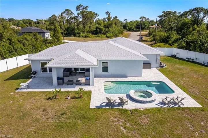 View of pool with a fenced backyard, a pool with connected hot tub, a patio, and a yard