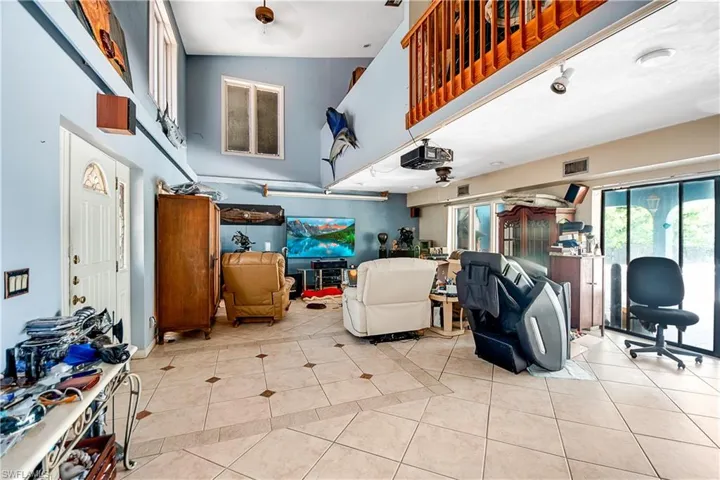 Tiled living room featuring high vaulted ceiling