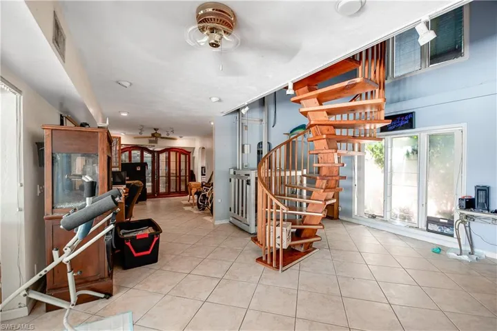 Living room with ceiling fan and light tile floors