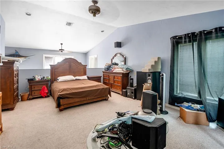 Bedroom with carpet flooring, ceiling fan, and lofted ceiling