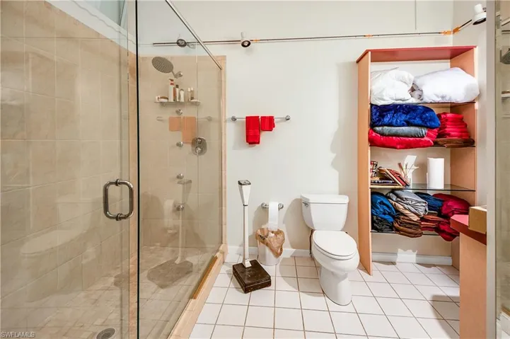 Bathroom featuring tile floors, an enclosed shower, and toilet