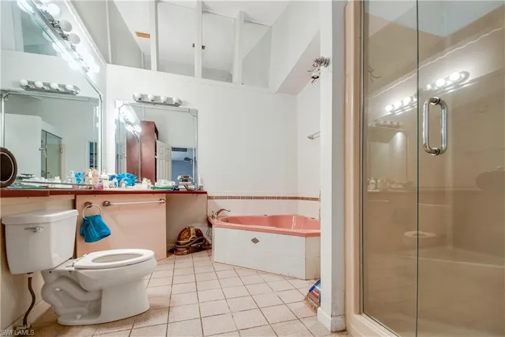 Bathroom featuring tile floors, shower with separate bathtub, and toilet