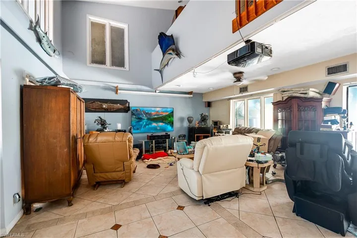 Living room featuring ceiling fan and light tile flooring