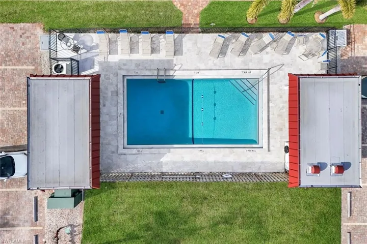 Community swimming pool with surrounding paver deck and ample lounge seating