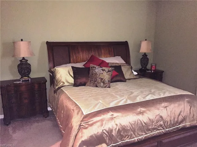 This bedroom features a dark wood bed frame with a prominent headboard, complemented by two matching dark wood nightstands