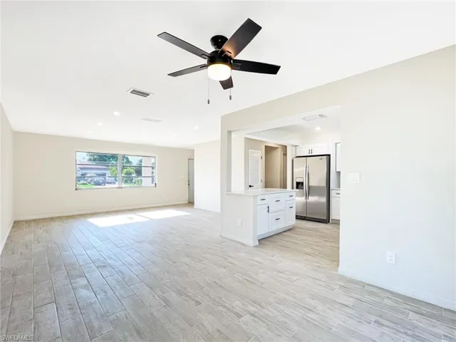 Unfurnished living room featuring light hardwood / wood-style floors and ceiling fan