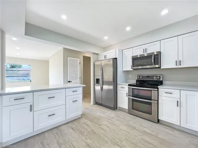 Kitchen featuring stainless steel appliances, light wood-type flooring, and white cabinetry