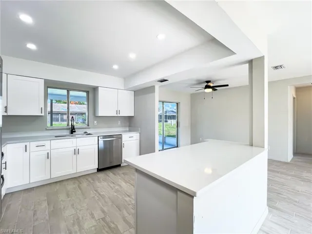 Kitchen with ceiling fan, white cabinets, sink, plenty of natural light, and dishwasher