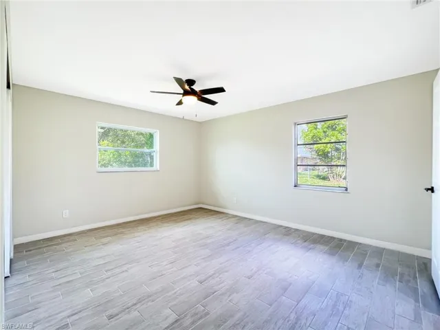 Empty room with ceiling fan and light hardwood / wood-style flooring