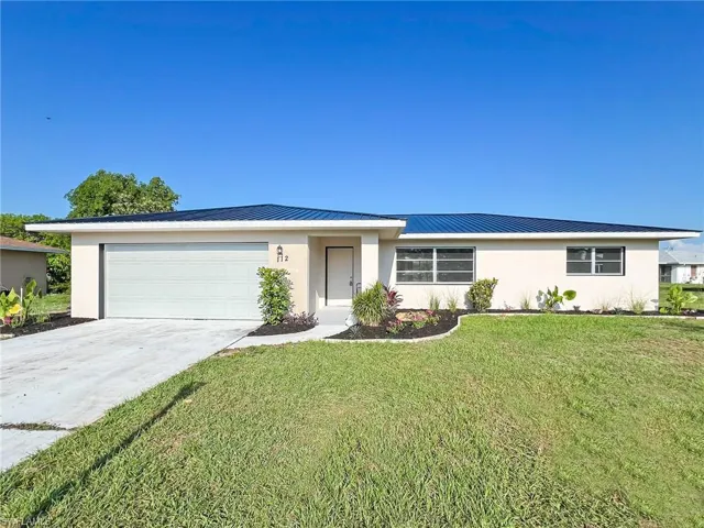 Ranch-style house featuring a garage and a front yard