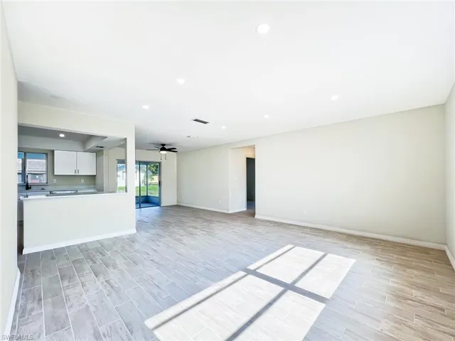Unfurnished living room featuring ceiling fan and light hardwood / wood-style flooring