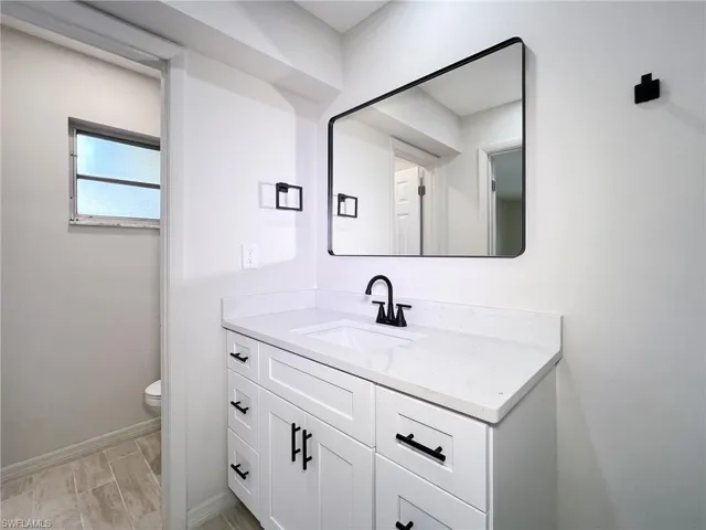 Bathroom featuring toilet and vanity with extensive cabinet space