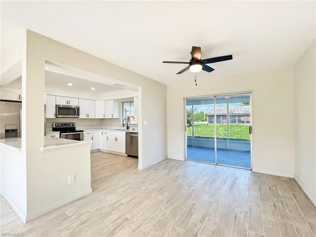 Kitchen with ceiling fan, light hardwood / wood-style floors, sink, white cabinetry, and appliances with stainless steel finishes