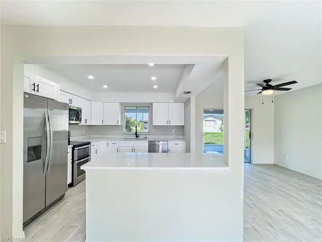 Kitchen featuring ceiling fan, stainless steel appliances, a healthy amount of sunlight, and light hardwood / wood-style flooring